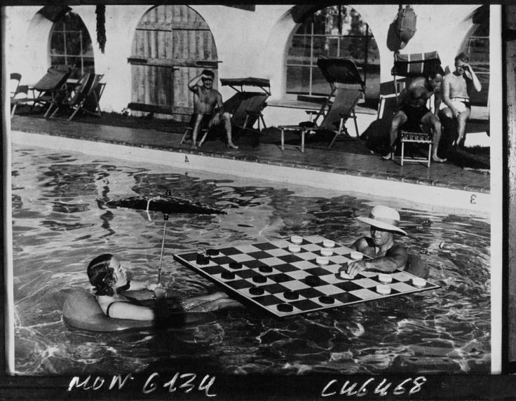 Baigneurs jouant au jeu de dames sur un échiquier flottant dans une piscine de Los Angeles. Photographie de presse. Acmé, 1932